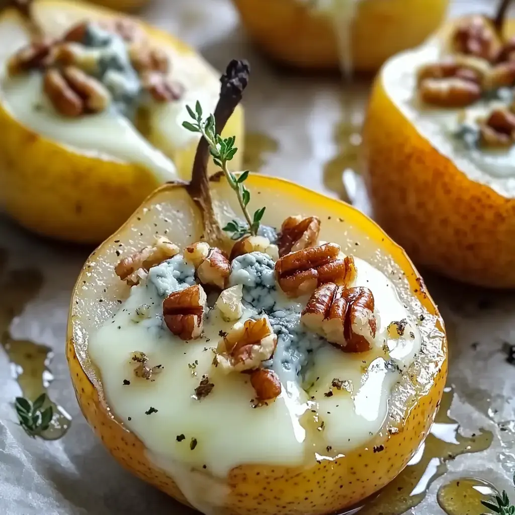 Moitiés de poires rôties garnies de fromage bleu, de noix de pécan et d'une touche de thym, nappées de miel.