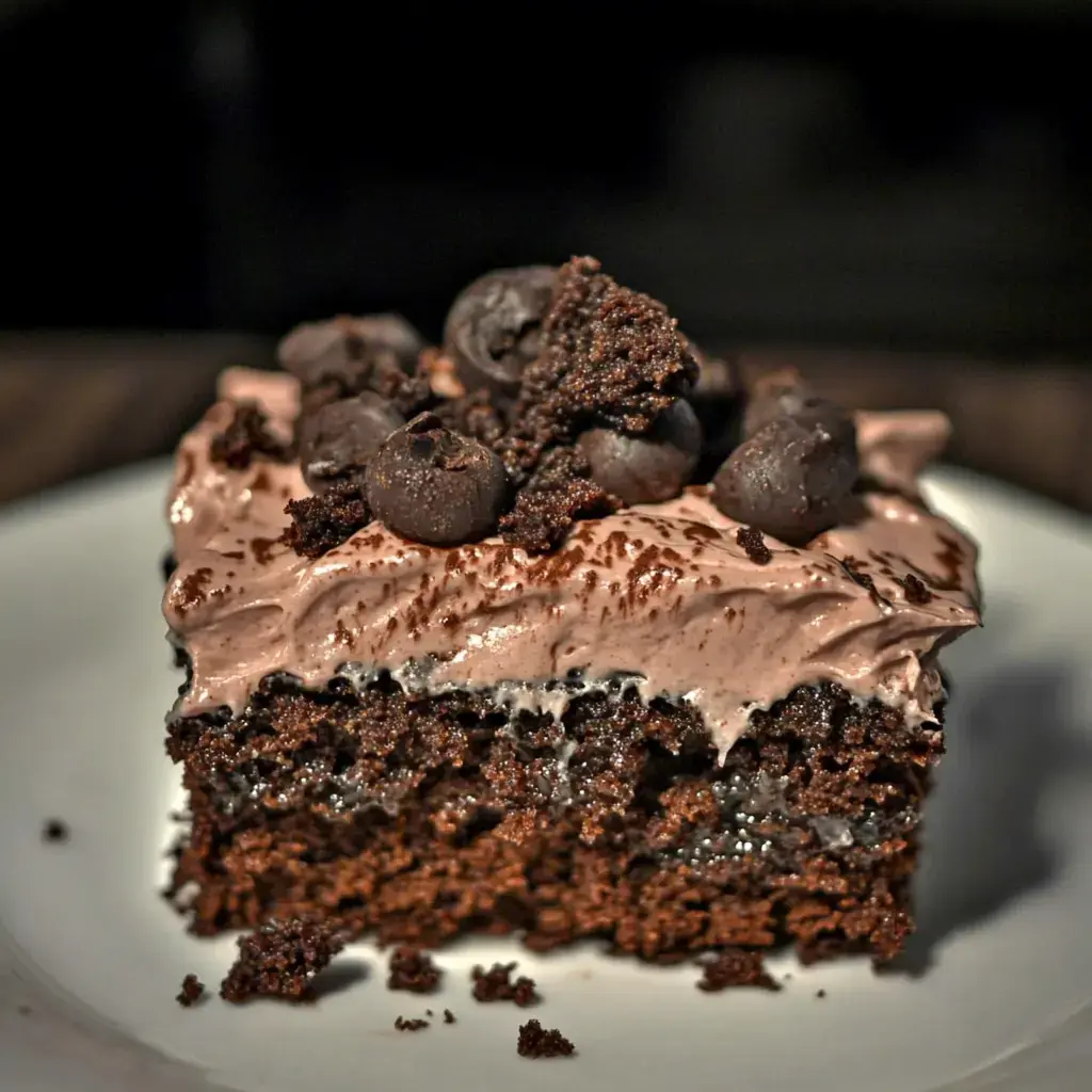 Une part de gâteau chocolat garnie de crème fouettée et miettes de chocolat noir.