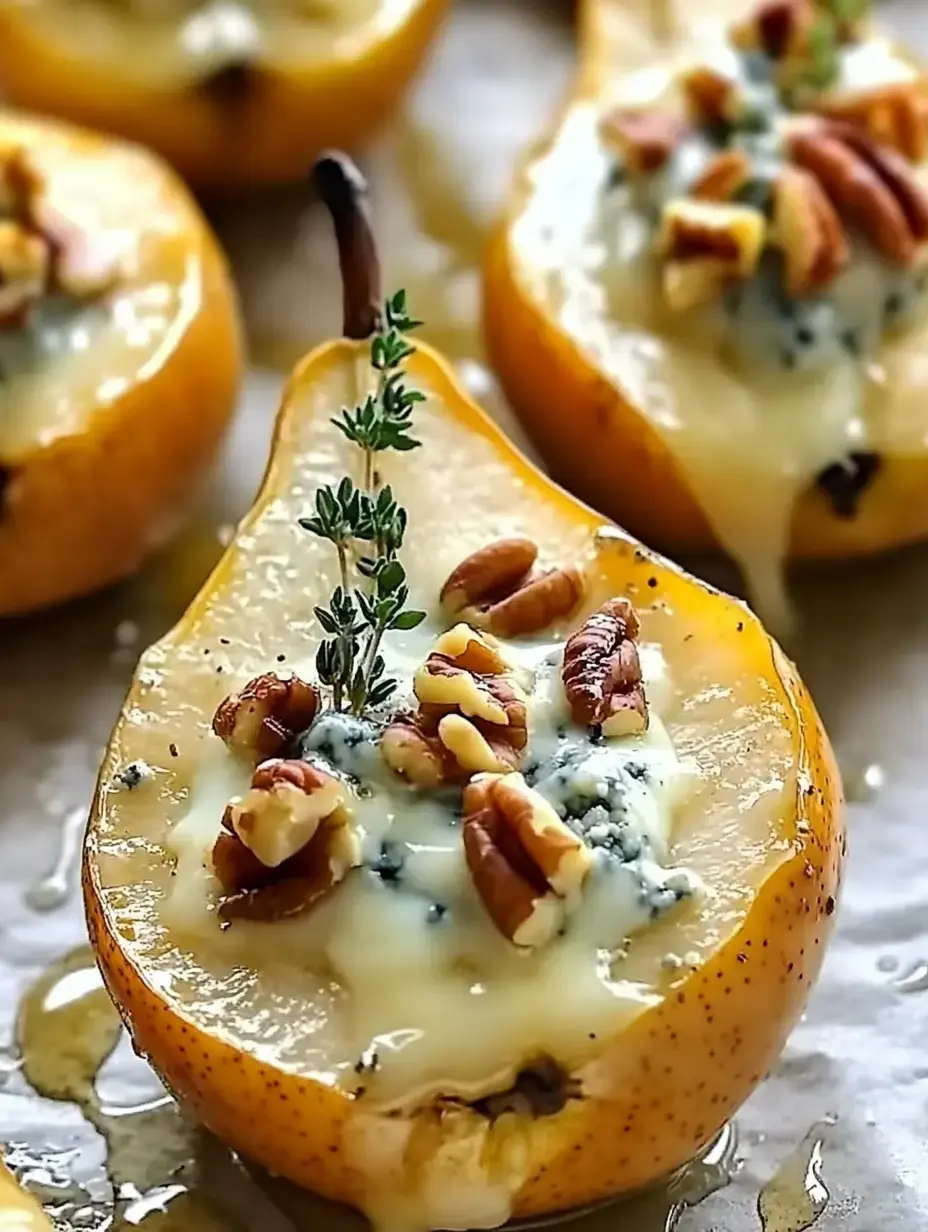 Poires cuites coupées en deux garnies de roquefort, noix hachées et brin de thym, nappées de miel.